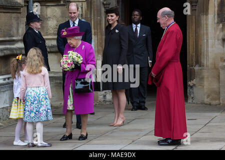 Windsor, Großbritannien. Der 1. April 2018. Madeleine Carleston und Amelia Vivian, beide im Alter von 6, geben die traditionellen posies von Blumen an die Königin, als sie den Ostersonntag Service in der St. George's Chapel in Windsor Castle verlässt. Credit: Mark Kerrison/Alamy leben Nachrichten Stockfoto