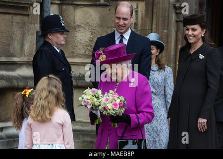 Windsor, Großbritannien. Der 1. April 2018. Madeleine Carleston und Amelia Vivian, beide im Alter von 6, geben die traditionellen posies von Blumen an die Königin, als sie den Ostersonntag Service in der St. George's Chapel in Windsor Castle verlässt. Credit: Mark Kerrison/Alamy leben Nachrichten Stockfoto