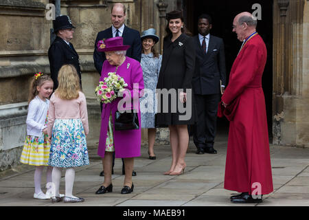 Windsor, Großbritannien. Der 1. April 2018. Madeleine Carleston und Amelia Vivian, beide im Alter von 6, geben die traditionellen posies von Blumen an die Königin, als sie den Ostersonntag Service in der St. George's Chapel in Windsor Castle verlässt. Credit: Mark Kerrison/Alamy leben Nachrichten Stockfoto