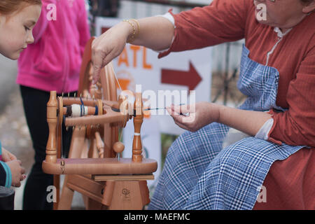 Atlanta, Georgia, USA - 07. Oktober 2012: Junges Mädchen, das beim Sommerfest die Frau beim Weben beobachtet. Stockfoto