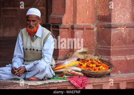 Lokaler Mann, die Blumen im Innenhof der Jama Masjid in Fatehpur Sikri, Uttar Pradesh, Indien. Die Moschee wurde im Jahre 1648 von Kaiser Shah Jahan erbaut Stockfoto