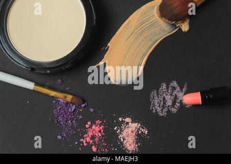 Bis zu schließen. Make-up-Pinsel, Puder und Creme Anschläge auf schwarzem Hintergrund. Stockfoto