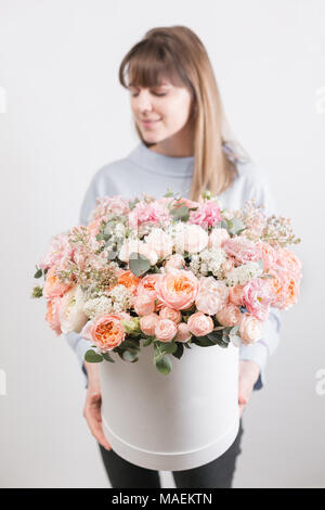 Blumen. schönen Luxus Blumenstrauß in der Frau die Hand. Die Arbeit des Floristen zu einem Blumenladen. Weiße runde Box Stockfoto