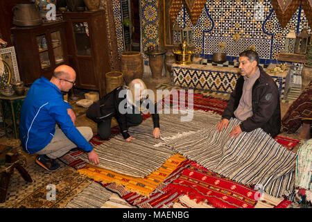 Marokko, Fes, Fes el Bali, Medina, Antiquitäten Shop, Touristen anzeigen Teppiche Stockfoto