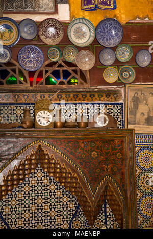 Marokko, Fes, Fes el Bali, Medina, Antiquitäten Shop im historischen Haus Platten und Uhren auf traditionellen geschnitzten Holz und zellij Fliesen- Feuer surrou Stockfoto
