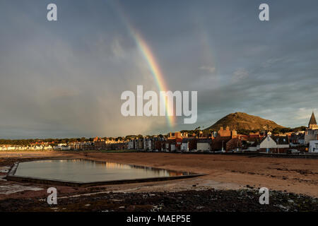 Ein Regenbogen über North Berwick mit den Gezeiten- pool im Vordergrund, East Lothian, Schottland Stockfoto