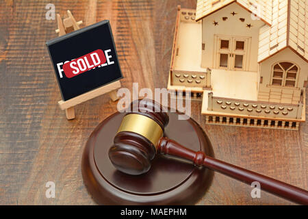 Haus verkauft Konzept mit Hammer und 3D Haus Miniatur. Stockfoto