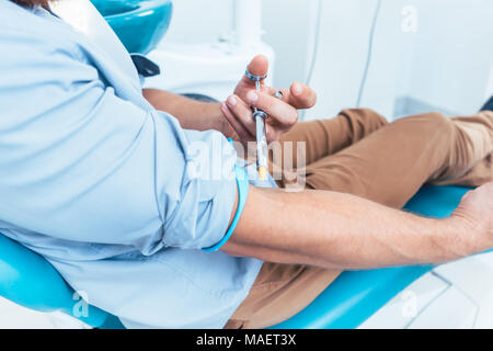 Patienten mit einer zahnmedizinischen Betäubungsmittel Spritze für die Injektion selbst Stockfoto