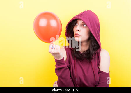 Frau, die dummen Gesichter mit einem Ballon in der Hand Stockfoto