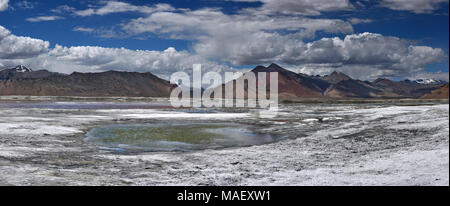 Hohen Berg Salzwüste mit einem kleinen blauen See unter weißen Böden, im Hintergrund Rosa Berge, Ladakh, Himalaya, Nordindien, Foto panoram Stockfoto