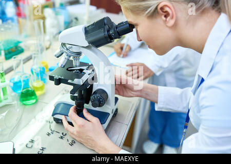 Konzentriert Chemiker einstellen Mikroskop Stockfoto