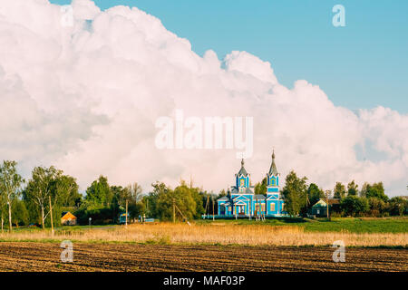 Ein Dorf Kirche aus Holz auf einem Hintergrund von Cumulus riesige Wolken gemacht. Krasnyy Partizan, dobrush Bezirk, Region Gomel, Belarus. Stockfoto