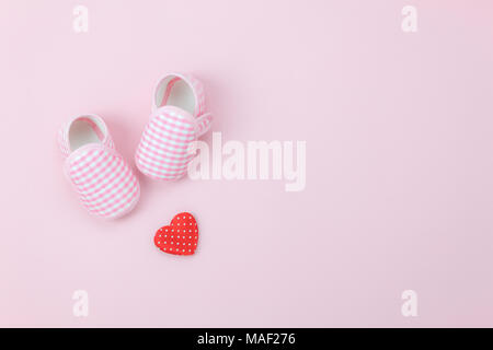 Tabelle Ansicht von oben Luftbild der Dekoration Happy Mother Tag Urlaub Hintergrund Konzept. Flach rot Herz & Baby Schuhe auf moderne schöne rosa Papier Stockfoto