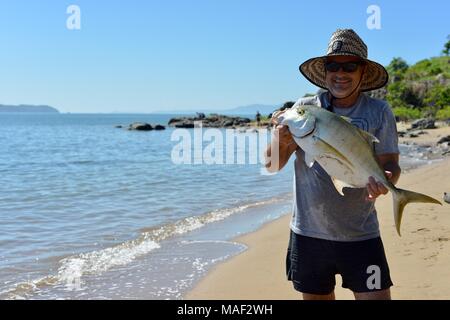 Stolz Fischer mit frischem Fang des Tages, wahrscheinlich Giant Trevally (Caranx Ignobilis) Shelly Cove Trail am Kap Pallarenda Conservation Park Stockfoto