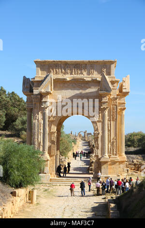 Touristen vor der rekonstruierten Bogen des Septimius Severus am Eingang zur antiken römischen Stadt Leptis Magna, Tripolis, Libyen Stockfoto