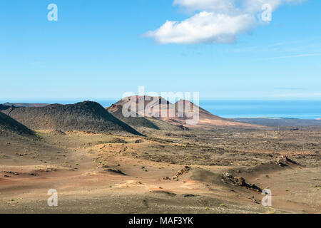 Straße durch grobe Lava Landschaft und bunten Vulkane in Timanfaya, Lanzarote, Spanien. Stockfoto