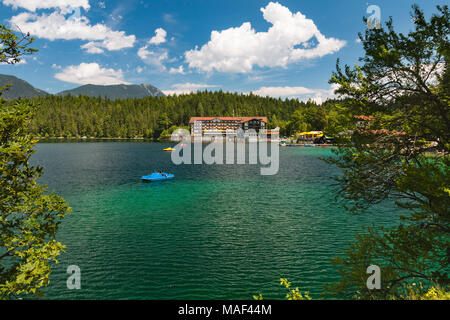 Ein großes Hotel am Eibsee in Grainau, Deutschland mit einigen Booten auf dem Wasser. Stockfoto