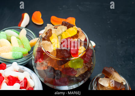 Lecker Gemischten bunten Bonbons jelly verschiedene Süßigkeiten auf schwarzem Hintergrund Stockfoto