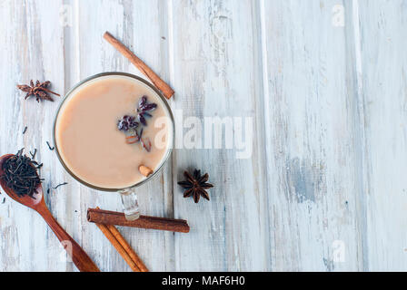 Heiße Tasse schwarzen Tee mit Milch und Zimt auf einen alten Holztisch, selektiver Fokus Stockfoto