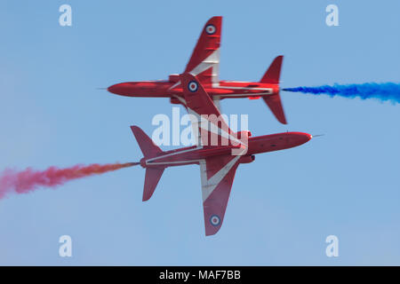 RAF Red Arrows-Flugzeuge, die in unmittelbarer Nähe aneinander vorbeifliegen Stockfoto