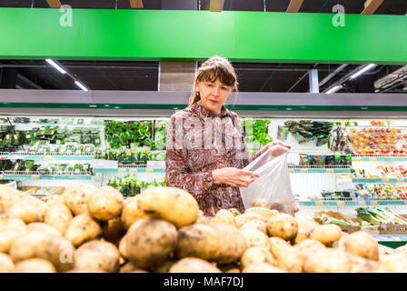 Samara, Russland - 16. September 2017: Junge Frau mit frischen Kartoffeln bei Shopping in Kette SB-Warenhaus. Stockfoto