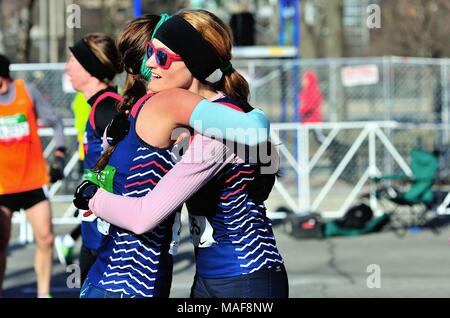 Chicago, Illinois, USA. Zwei Läufer gerade hinter der Ziellinie umarmen, nachdem das Paar beendet hatte, die 2018 Shamrock Shuffle Rennen. Stockfoto