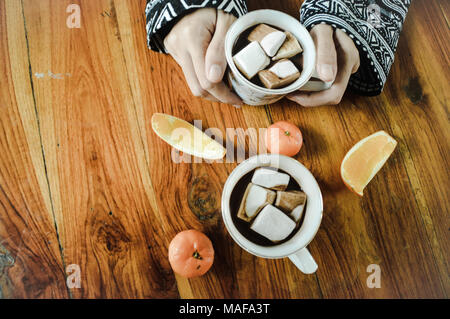 Gemeinsame Nutzung einer Tasse heißen Kakao trinken mit Marshmallows auf einem kalten am frühen Morgen Stockfoto