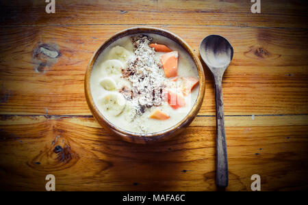 Smoothie Schale in Scheiben geschnittene Bananen, Papaya, Rosinen, Orangen und Hafer für eine gesunde vegane Frühstück für das Sommer Körpers Ziele Stockfoto