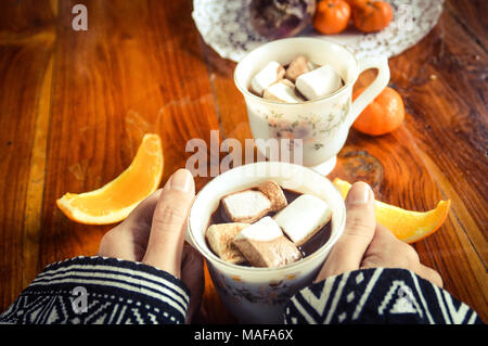 Gemeinsame Nutzung einer Tasse heißen Kakao trinken mit Marshmallows auf einem kalten am frühen Morgen Stockfoto