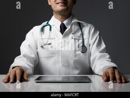 Männliche Arzt Hände mit Tablet Computer sitzen auf Schwarz isoliert. Stockfoto