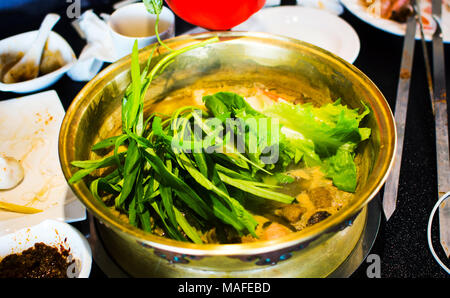 Stäbchen einsetzen, frisches Gemüse in hotpot Stockfoto