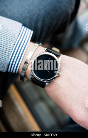 Stilvolle Mann in grauen Überbrückungsdraht hand elegante Business Mann mit Mode keine Marke Armbanduhr, Männer Mode und Accessoires closeup Schuß Stockfoto