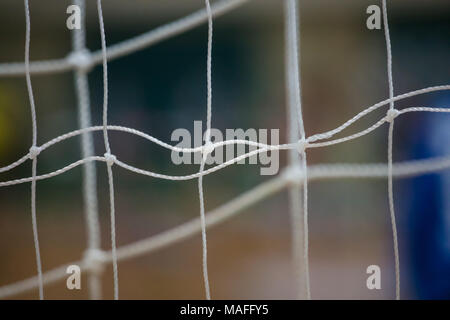 Sportliche Konzept. Fußball-Netze mit Knoten weiße Farbe, Nahaufnahme, hinter Anzeigen. Unscharfer Hintergrund Stockfoto
