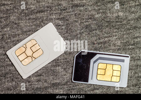 Zwei SIM-Karten auf grauem Tuch Textur Hintergrund isoliert Stockfoto
