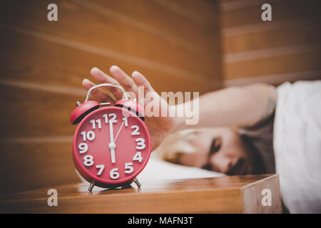 Mann, der versucht, die Wecker am Morgen aufwachen. Stockfoto
