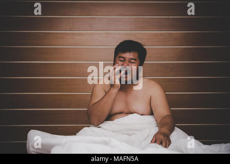 Portrait von reifer Mann streckte seine Arme auf dem Bett. Stockfoto