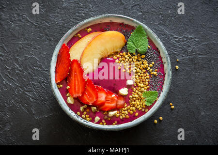 Acai Smoothie Schüssel mit Chia-Samen, Früchte, Beeren (Erdbeeren) und Blütenpollen für gesunde vegane Vegetarier Diät rohen Frühstück. Frühstück-smoothie Stockfoto