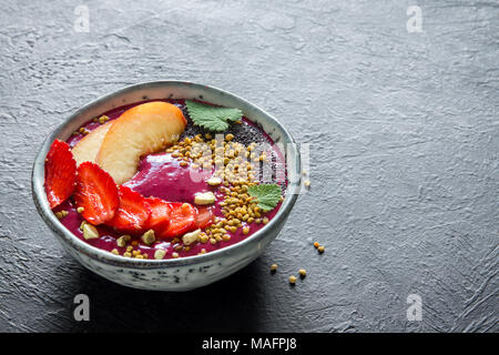 Acai Smoothie Schüssel mit Chia-Samen, Früchte, Beeren (Erdbeeren) und Blütenpollen für gesunde vegane Vegetarier Diät rohen Frühstück. Frühstück-smoothie Stockfoto