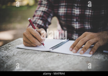 Mann Hand schreiben auf seinem Notebook. Stockfoto