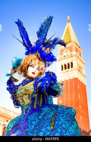 Venedig, Italien - 9. Februar 2018: Karneval von Venedig, schöne Frau Maske auf dem Markusplatz mit Campanile. Stockfoto