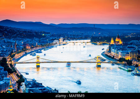 Budapest, Ungarn. Dramatischer Sonnenuntergang über Széchenyi Kettenbrücke und das Parlament, die Donau. Stockfoto