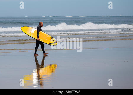 Hendaia, France-April 01,2018: Erwachsene Surfer aus dem Wasser kommt mit seinen gelben Brett, hendaia - Frankreich Stockfoto