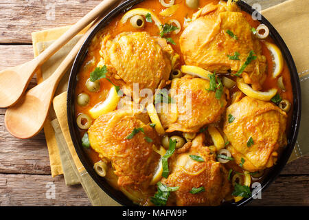 Marokkanisches Essen: tajine Hähnchen mit gesalzenen Zitronen, Zwiebeln und Oliven close-up auf dem Tisch. horizontal oben Ansicht von oben Stockfoto