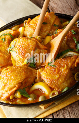 Tajine Hähnchen mit gesalzenen Zitronen, Zwiebeln und grünen Oliven close-up auf dem Tisch. Vertikale Stockfoto