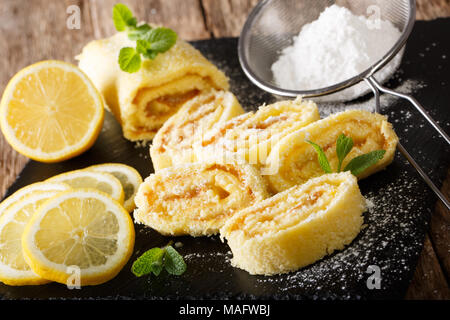 Hausgemachten Zitronenkuchen mit Früchten Creme, mit Minze und Puderzucker in der Nähe eingerichtet - auf den Tisch. Horizontale Stockfoto