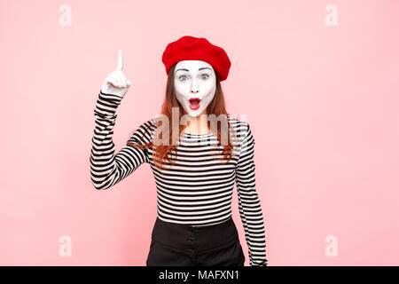 Stattliche Frau haben tolle Idee, mit dem Finger auf. Clown, Artist, Mime. Studio shot, rosa Hintergrund Stockfoto