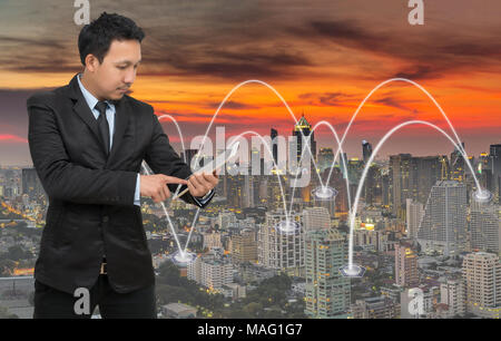 Asiatische Geschäftsmann aufrufen Handy mit Netzwerkverbindung auf stadtbild Hintergrund, Business Connection Konzept Stockfoto