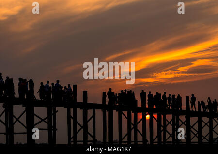 Sonnenuntergang mit Silhouetten von vielen Leuten auf der U-Bein Brücke ist die längste in Amarapura, Mandalay, Myanmar Stockfoto