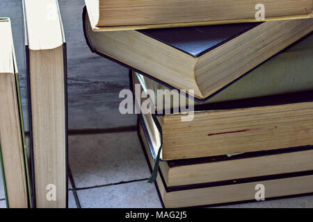 Einen Stapel alte verstaubte Bücher übereinander gestapelt Stockfoto