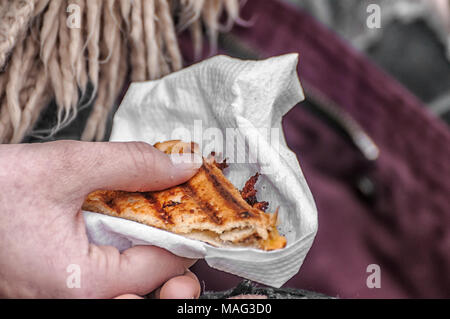 Ein Sandwich auf einer weißen Serviette in der Hand gehalten Stockfoto